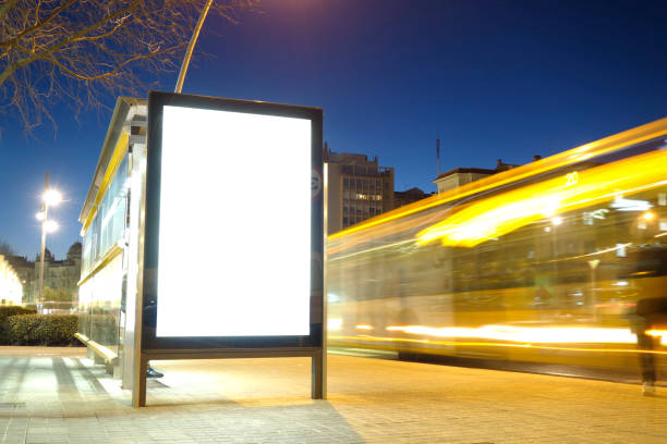 Blank advertisement mock up in a bus stop Blank advertisement mock up in a bus stop, with blurred traffic lights at night publicity event stock pictures, royalty-free photos & images