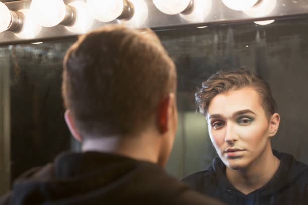 istock Young man at dressing room mirror, with make-up 910634218