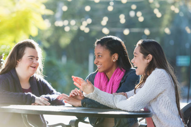 istock Three teenage friends talking, one with down syndrome 910637268