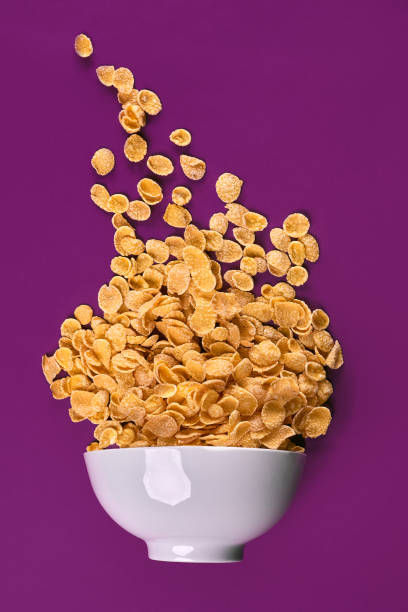 чаша с кукурузными хлопьями на красочном фоне - cereal box food carbohydrate стоковые фото и изображения