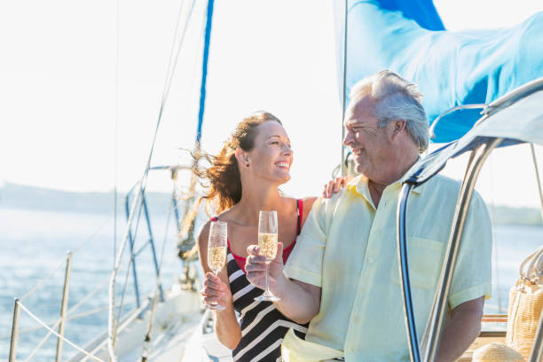 istock Mature couple on a sailboat drinking champagne 910640864