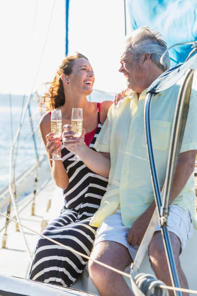 istock Mature couple on a sailboat drinking champagne 910640868