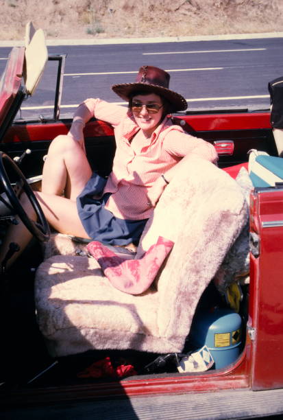 den siebziger jahren. eine junge frau auf dem weg auf den straßen der türkei mit einem roten käfer cabrio für urlaub. - tourist fotos stock-fotos und bilder
