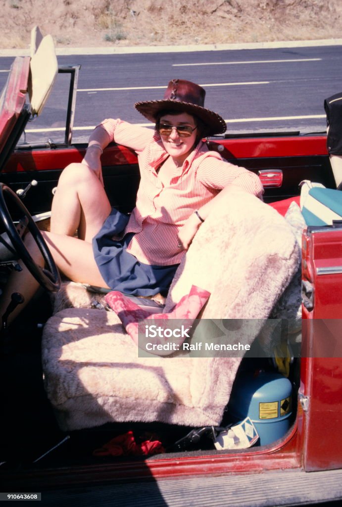 The Seventies. A young woman enroute on the streets of Turkey with a red beetle convertible for vacation. Turkey, June 1974. A young woman enroute with ared beetle convertible on the streets of Turkey. Archival Stock Photo