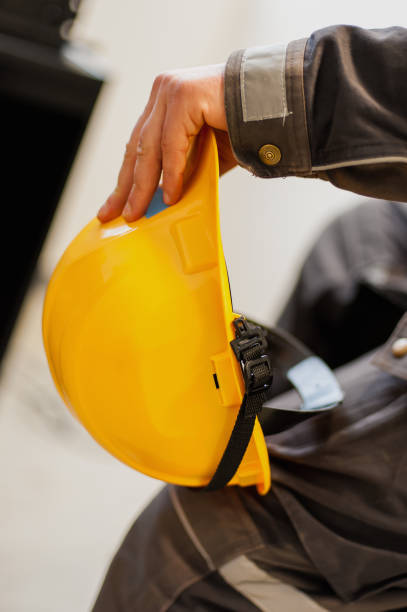 istock Worker holds yellow protective helmet in his hand 910648790