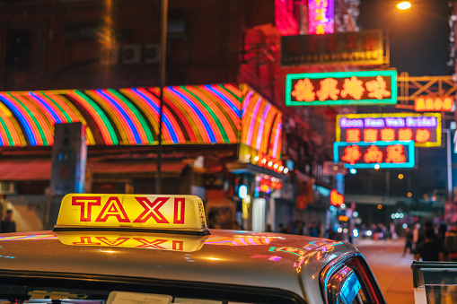 Taxi sign, colorful night street road in Hongkong with neonsigns
