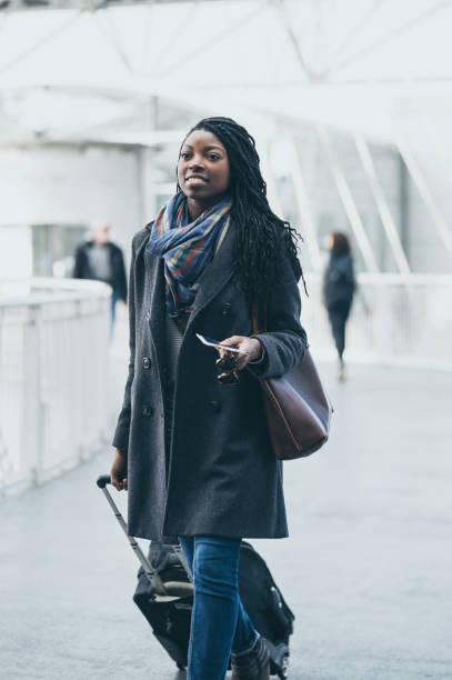 istock Young woman at airport pulling luggage 910651708
