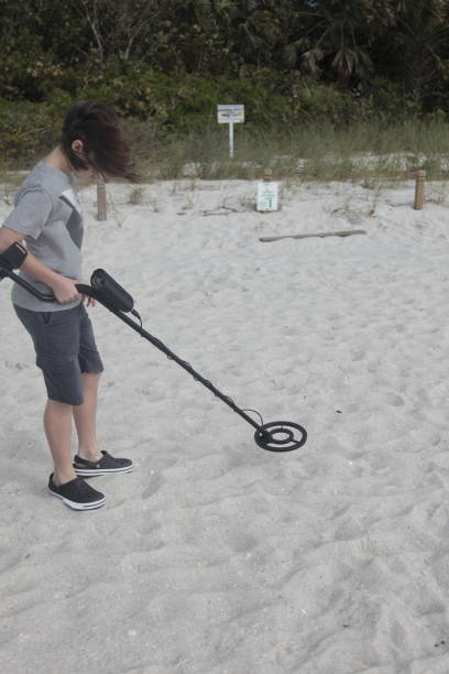 istock Boy with metal detector on a beach. 910654368
