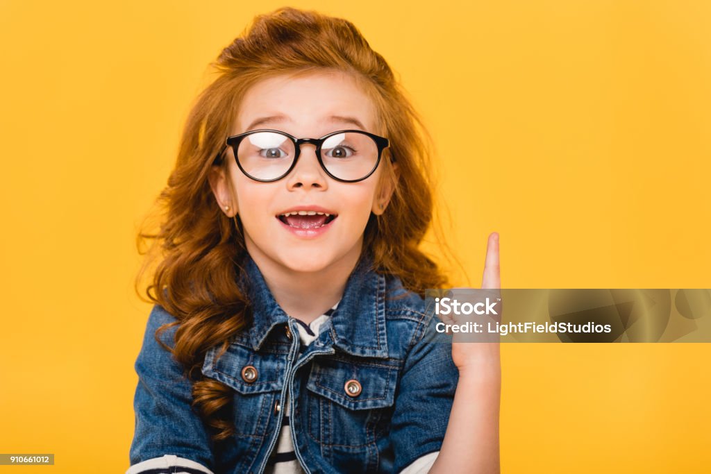 ritratto di bambino sorridente in occhiali che puntano isolato su giallo - Foto stock royalty-free di Bambino