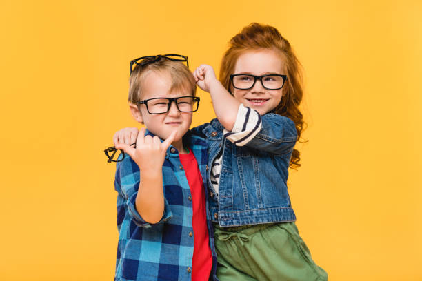 portret uśmiechniętych dzieci w okularach odizolowanych na żółto - child glasses eyewear little girls zdjęcia i obrazy z banku zdjęć