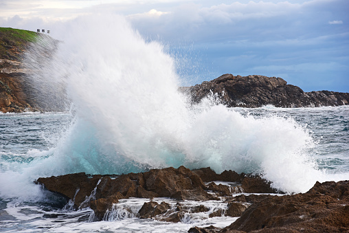 Wave crashing against a rock in Alghero shore, Italy