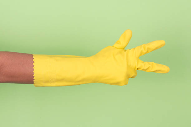 istock Yellow glove on hand shows number three 910707296