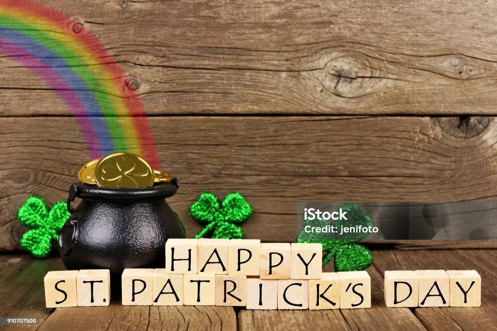 Happy St Patricks Day blocks with decor against wood Happy St Patricks Day wooden blocks with Pot of Gold, rainbow and shamrocks against rustic wood St. Patrick's Day Stock Photo