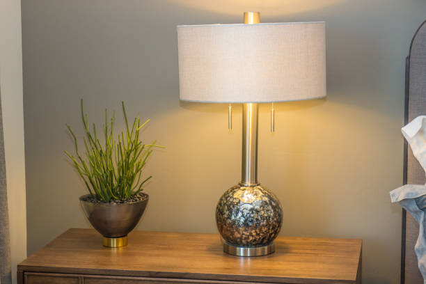 istock Lamp & Plant On Night Stand In Modern Bedroom 910711298