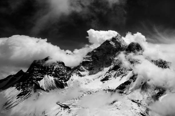 Nepal mountain range shot in black and white, with a mix of dramatic clouds and sunshine, along the trail to Mount Everest