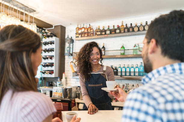istock Waitress serving coffee to customers at a cafe 910715016