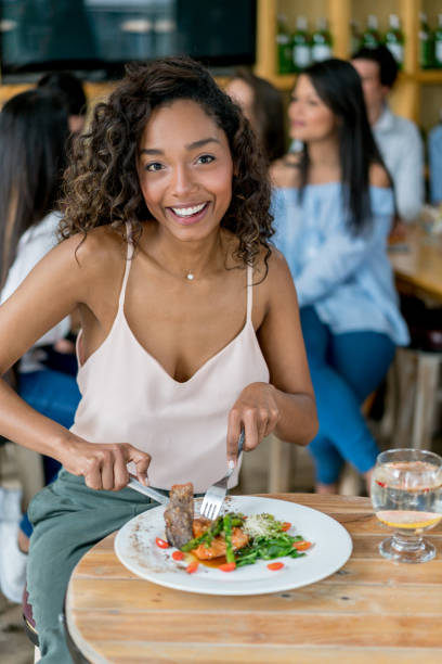 istock Happy woman eating by herself at a restaurant 910715036