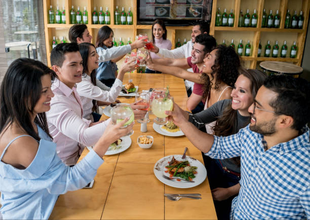 istock Group of friends making a toast while having dinner at a restaurant 910715154