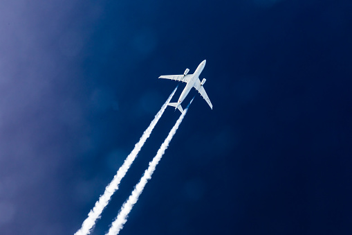 Airbus 330 of Etihad Airways in 33000 feet. Flying in blue sky and drawing a Condensation Trail, Contrail. These vapor trails are small particle out of the fuel which condensates on cloud condensation nuclei. The vertical separation is 2000 feet for this photo