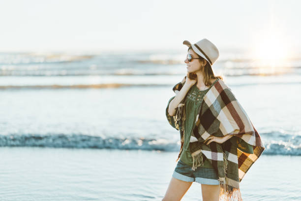 istock Boho style woman with hat having fun near the ocean 910722558