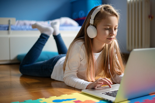 Young girl in her room listening to music.