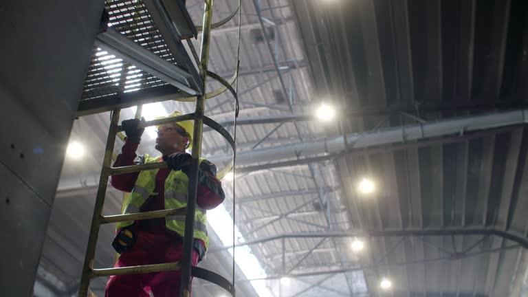 Steelworker climbing ladder in steel mill