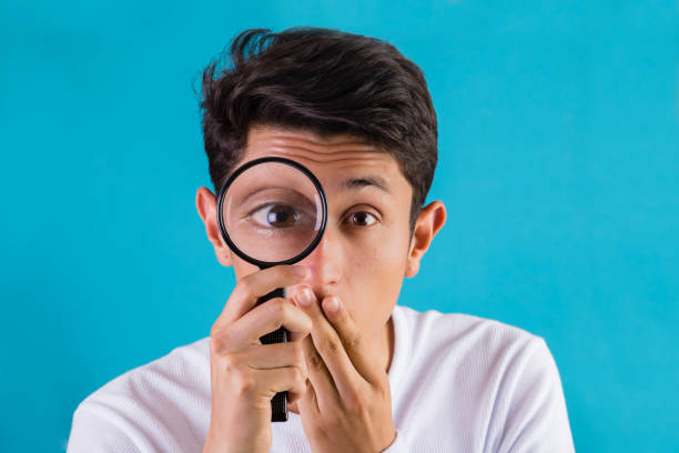 Casual teenager with a magnifying glass stock photo