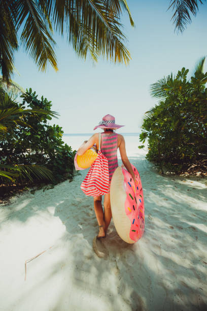mujer hipster caminando por la selva en la carretera a la costa, maldivas - aura fotografías e imágenes de stock