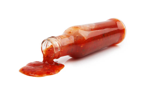 hot sauce on white bottle of hot sauce is spilling liquid on white background tabasco state stock pictures, royalty-free photos & images