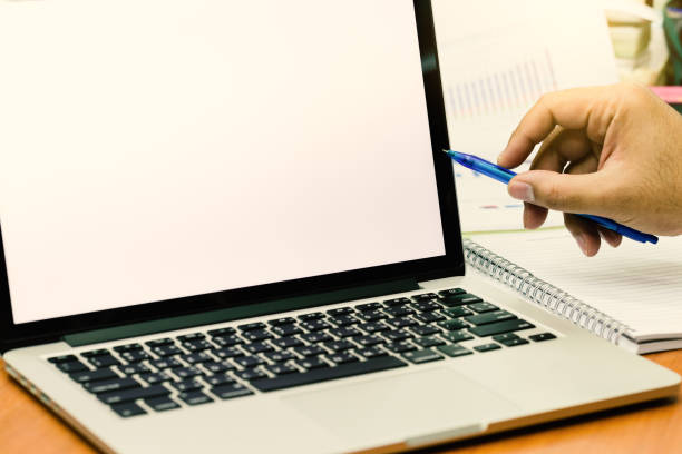 istock Businessman hands use pen pointing to laptop screen with copy space. (Vintage tone) 910733244