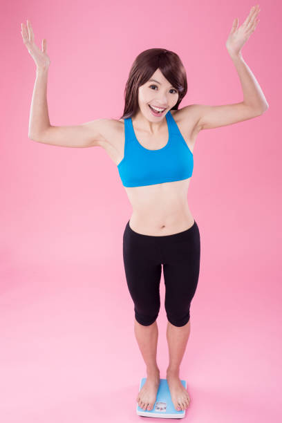 istock woman stand on weight scale 910733622