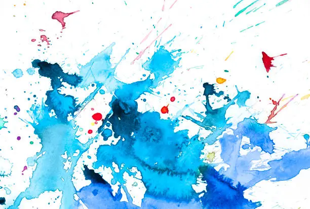 Abstract wet blue watercolor background with splashes on white watercolor paper. My own work.