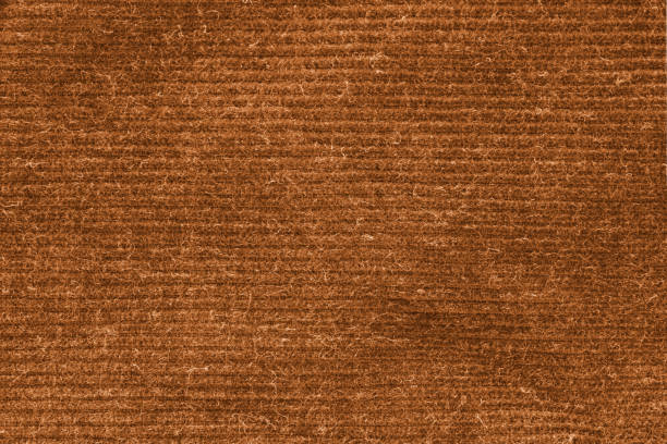 Close-up view of brown canvas fabric with visible fibers and distressed texture, ideal for use as a rustic or vintage background.