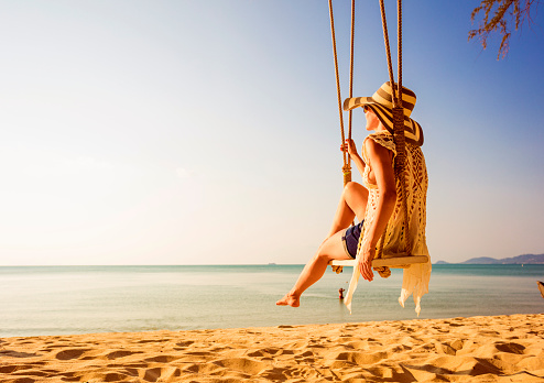 Woman sitting at tropical swing
