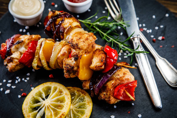 istock Kebabs - grilled meat and vegetables on wooden background 910772888