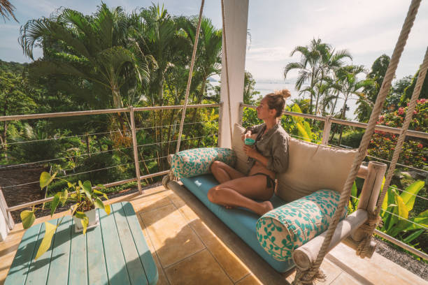 donna allegra che si rilassa nel patio sulla giungla, thailandia - tea island foto e immagini stock