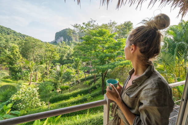 istock Young woman enjoying the view from tree house, Thailand 910778532