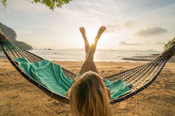 istock Woman relaxing in a hammock on the beach 910778806