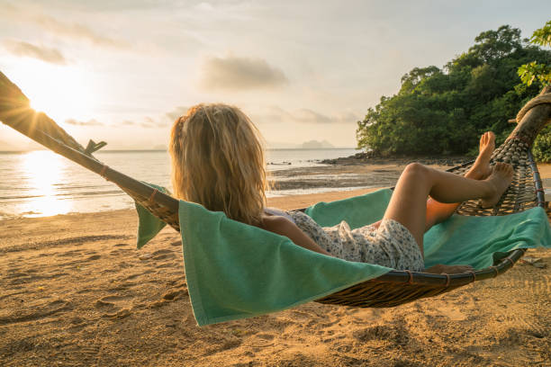 istock Woman relaxing in hammock on tropical beach 910779050