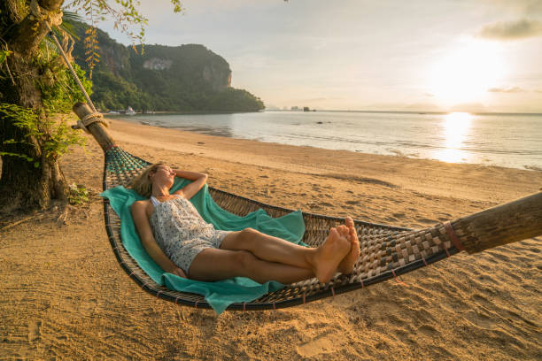istock Young woman on hammock by the beach, Thailand 910779166