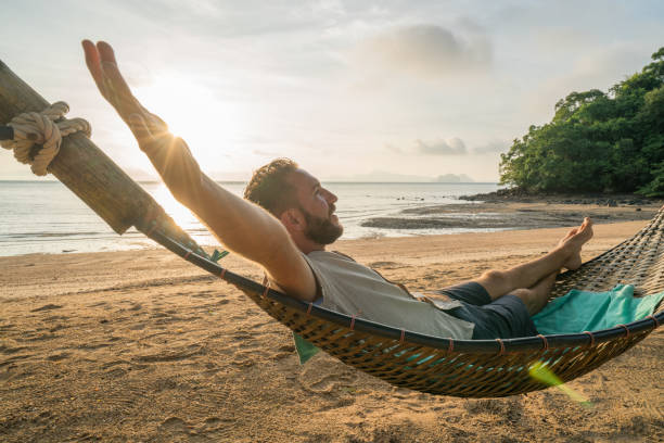 istock Relaxing time, man on hammock arms outstretched 910779406