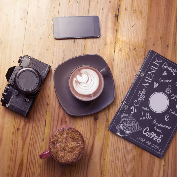 istock Cappuccino, creme brulee coffee latte, and camera on wooden background 910779448