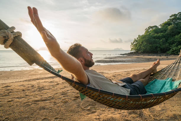 istock Relaxing time, man on hammock arms outstretched 910779464