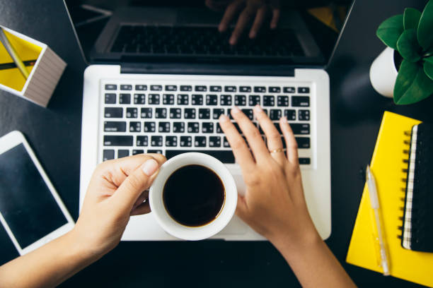 istock Holding coffee cup and typing keyboard in office 910779830