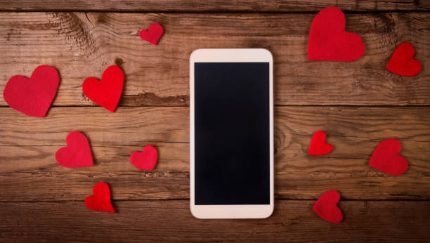istock Mobile phone with hearts romantic wallpaper 910782064