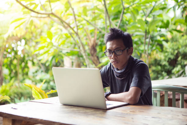 istock A man is working using laptop at park / outdoor cafe 910782326