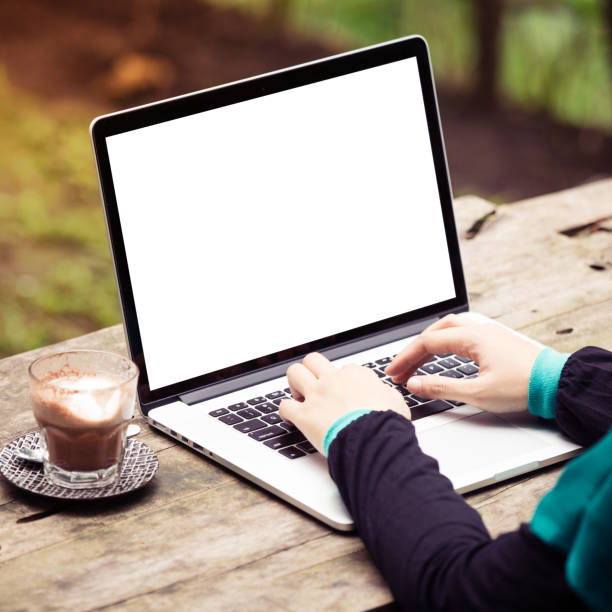 istock A woman is working using laptop at park / outdoor cafe, blank screen for background 910782502