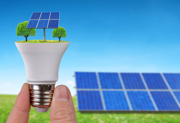 istock Eco LED light bulb with solar panels in hand. 910786712