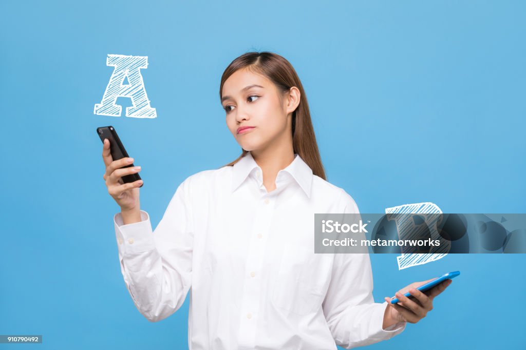 Young woman comparing smartphone A with smartphone B. Comparison Stock Photo