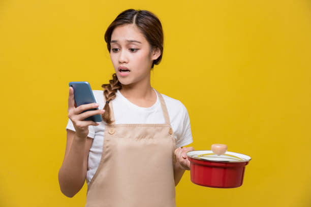 textos de la jeune femme pendant la cuisson - cooking fail photos et images de collection